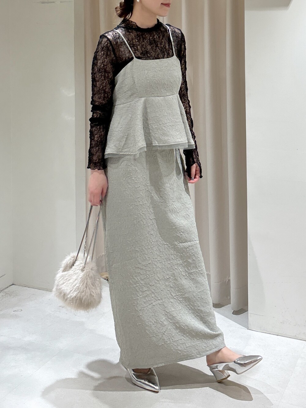 グリーン系のワンピース、ブラック系のTシャツ/カットソー、ベージュ系のショルダーバッグを着用したレディースの冬コーディネートの6枚目の写真