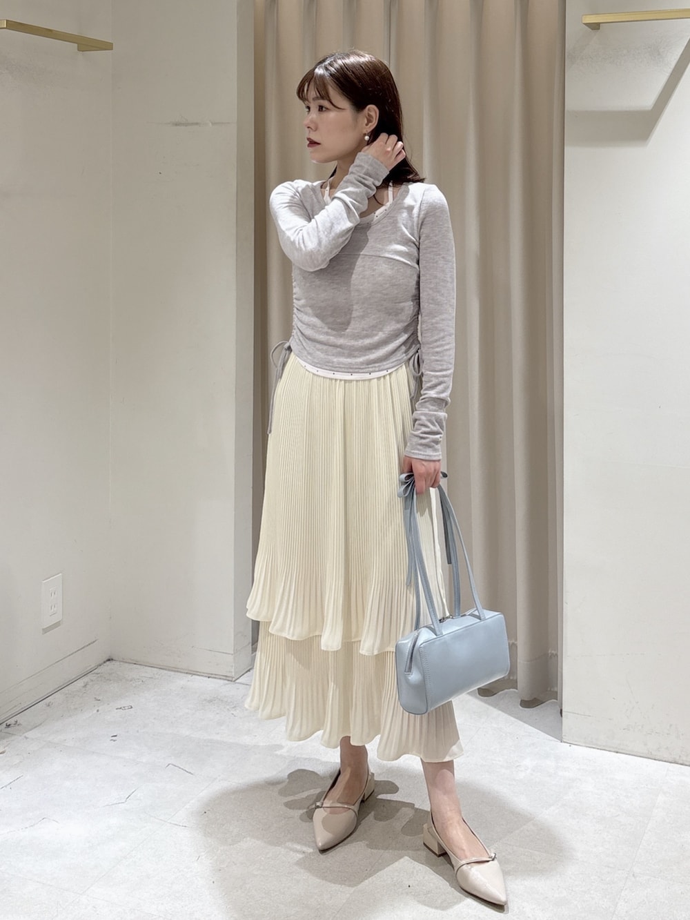 ベージュ系のテーラードジャケット、グレー系のTシャツ/カットソー、ホワイト系のスカートを着用したレディースの春コーディネートの5枚目の写真