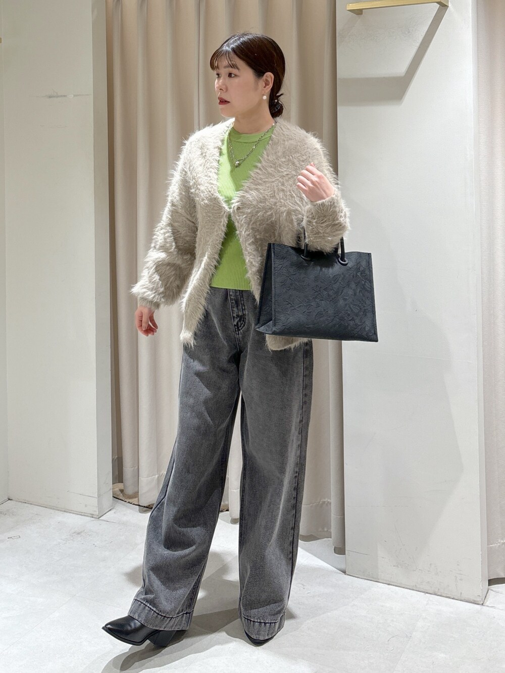 ベージュ系のカーディガン/ボレロ、ブラック系のデニムパンツ、ブラック系のトートバッグを着用したレディースの冬コーディネートの3枚目の写真