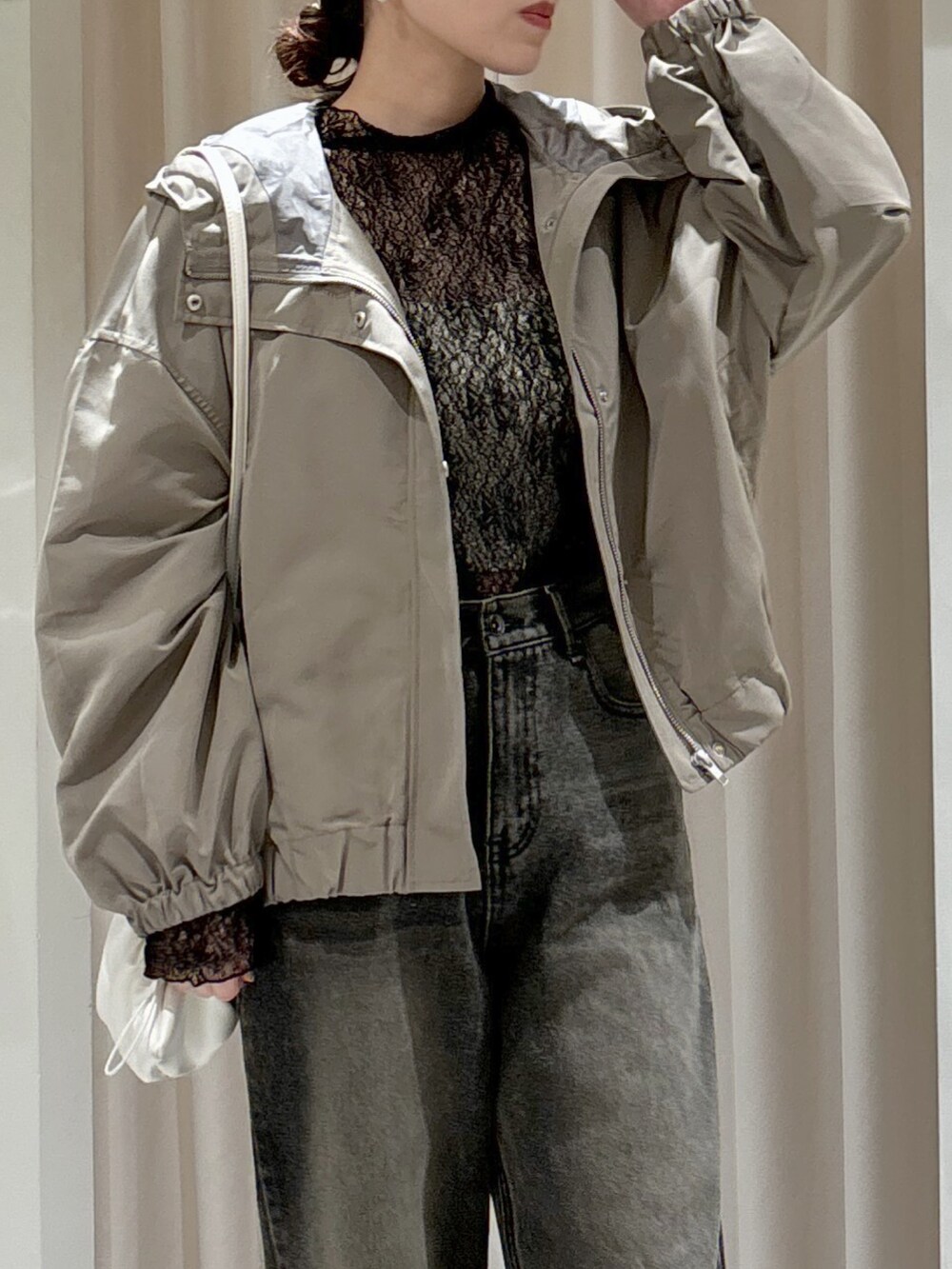 グリーン系のマウンテンパーカー、ブラック系のTシャツ/カットソー、ホワイト系のキャミソールを着用したレディースの冬コーディネートの6枚目の写真