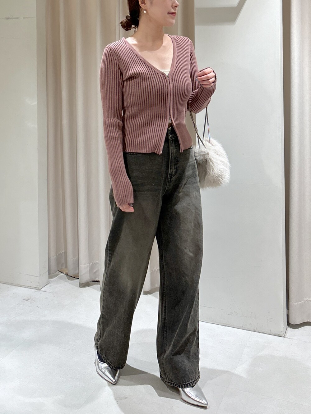 ピンク系のニット/セーター、ホワイト系のキャミソール、ベージュ系のショルダーバッグを着用したレディースの冬コーディネートの2枚目の写真