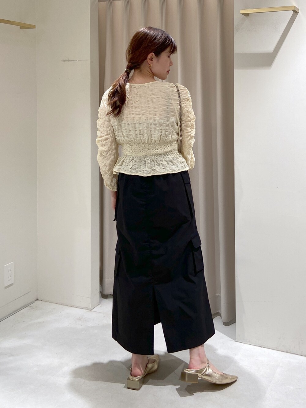 ホワイト系のカーディガン/ボレロ、グレー系のキャミソール、ブラック系のショルダーバッグを着用したレディースの春コーディネートの3枚目の写真