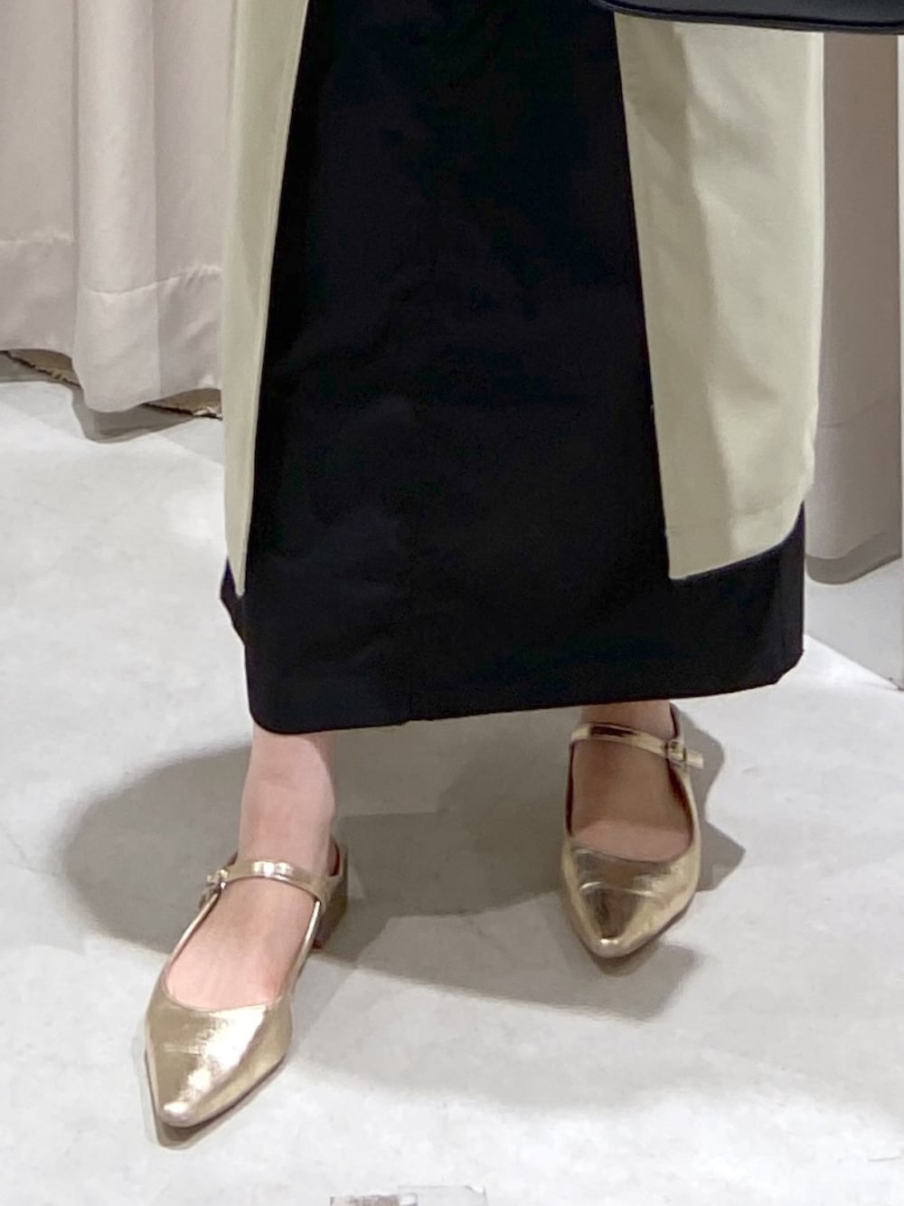 グリーン系のトレンチコート、ブラック系のショルダーバッグ、グリーン系のニット/セーターを着用したレディースの春コーディネートの4枚目の写真