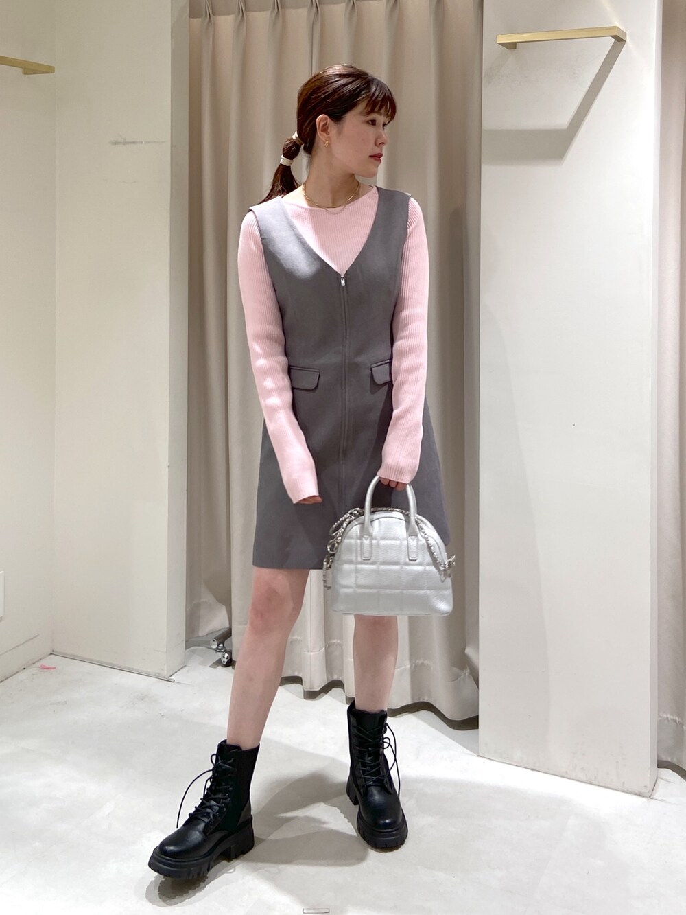 グレー系のワンピース、シルバー系のショルダーバッグ、ブラック系のブーツを着用したレディースの春コーディネートの4枚目の写真