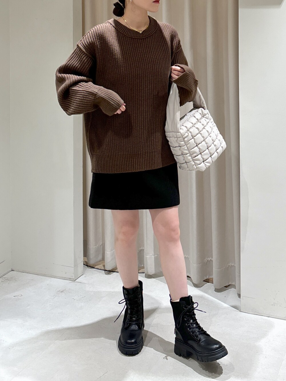 ブラウン系のニット/セーター、ホワイト系のハンドバッグ、ブラック系のスカートを着用したレディースの秋コーディネートの5枚目の写真