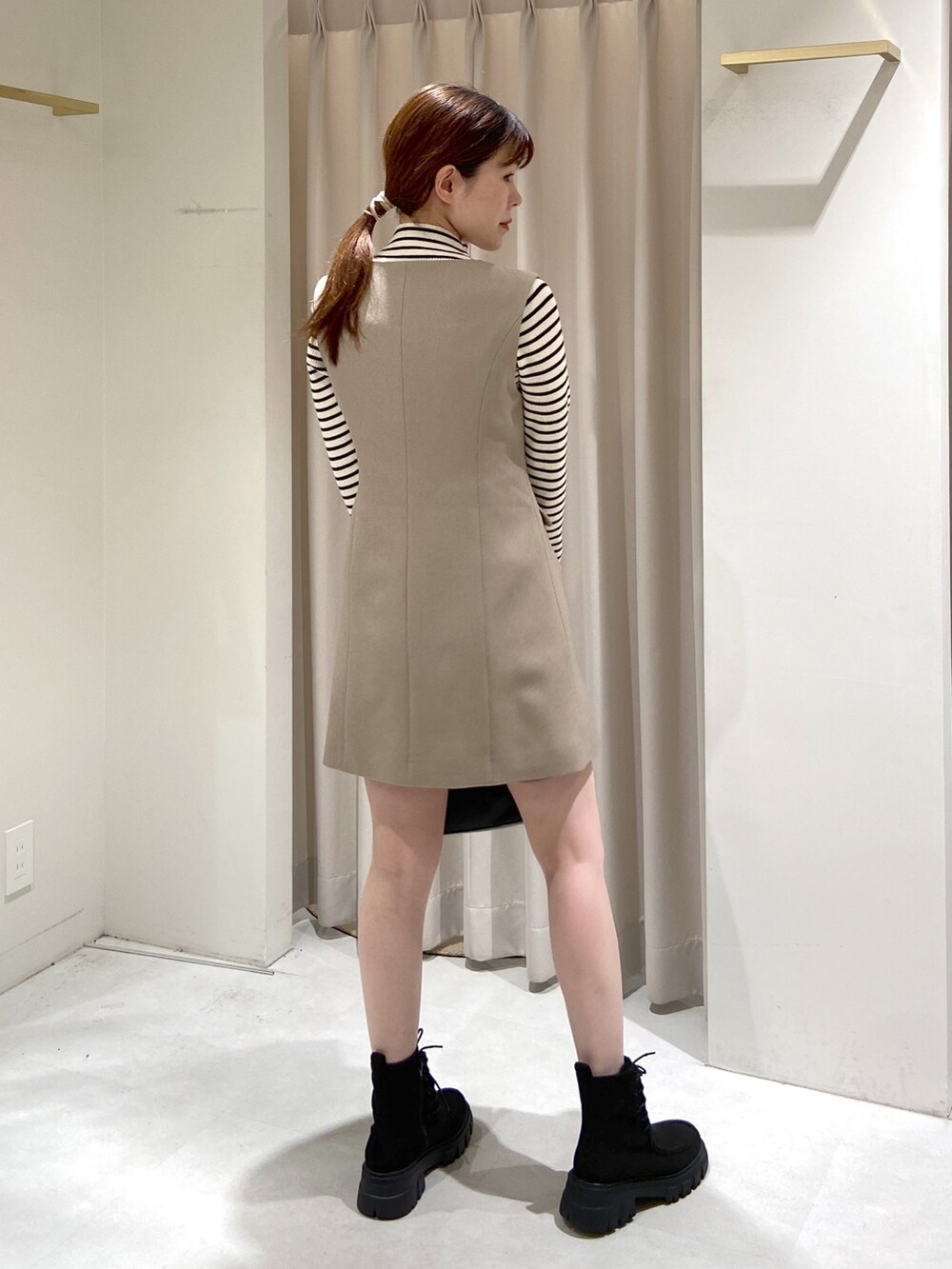 ベージュ系のワンピース、ホワイト系のニット/セーター、ブラック系のショルダーバッグを着用したレディースの冬コーディネートの4枚目の写真