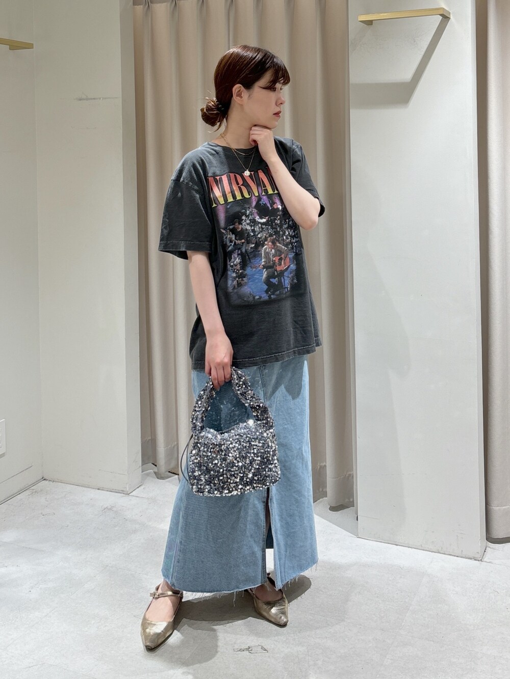 ブルー系のデニムスカート、ゴールド系のパンプス、ブラック系のTシャツ/カットソーを着用したレディースの春コーディネートの5枚目の写真