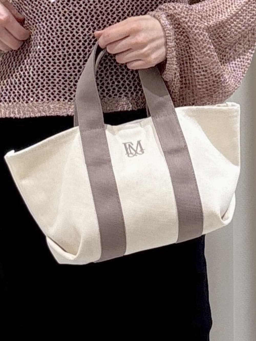 ピンク系のニット/セーター、ブラック系のキャミソール、グレー系のトートバッグを着用したレディースの春コーディネートの6枚目の写真