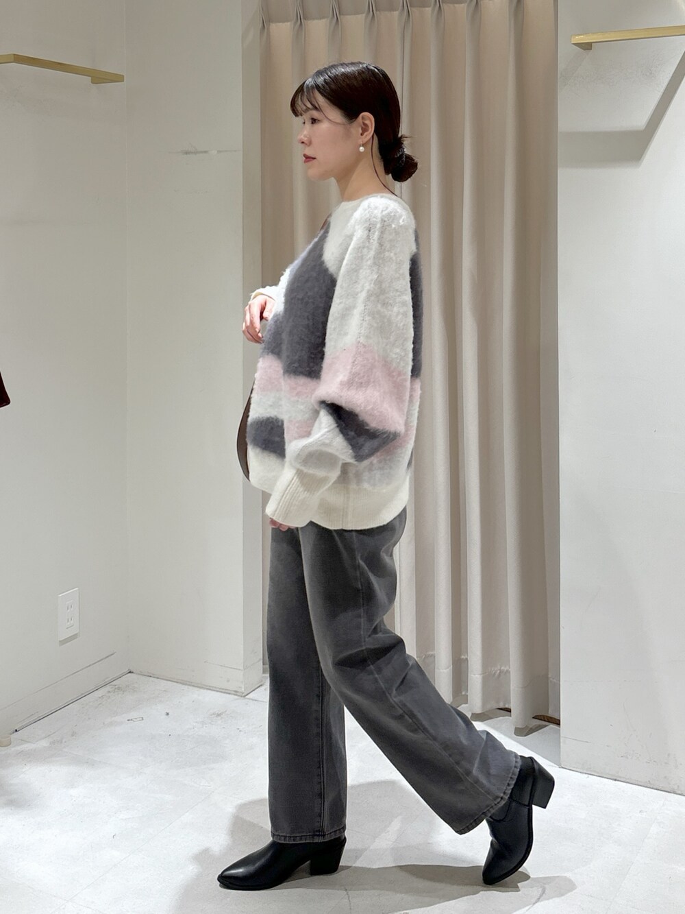 ホワイト系のニット/セーター、ブラウン系のトートバッグ、ブラック系のデニムパンツを着用したレディースの冬コーディネートの7枚目の写真