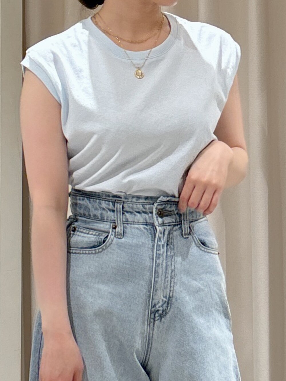 ブルー系のTシャツ/カットソー、ブルー系のデニムパンツ、ホワイト系のハンドバッグを着用したレディースの春コーディネートの7枚目の写真