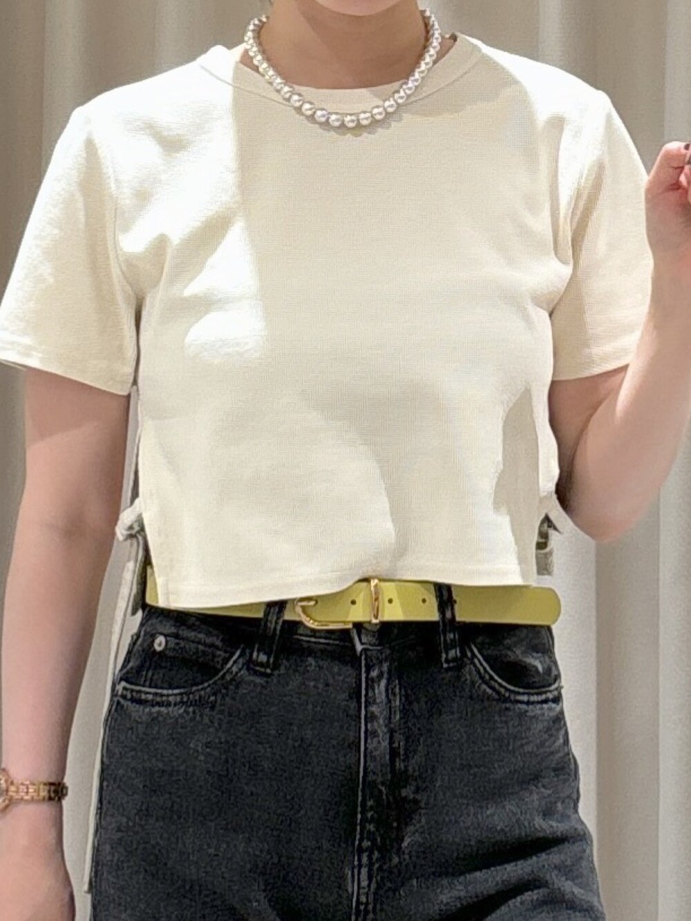 ホワイト系のTシャツ/カットソー、ブラック系のキャミソール、ブラック系のデニムパンツを着用したレディースの秋コーディネートの3枚目の写真