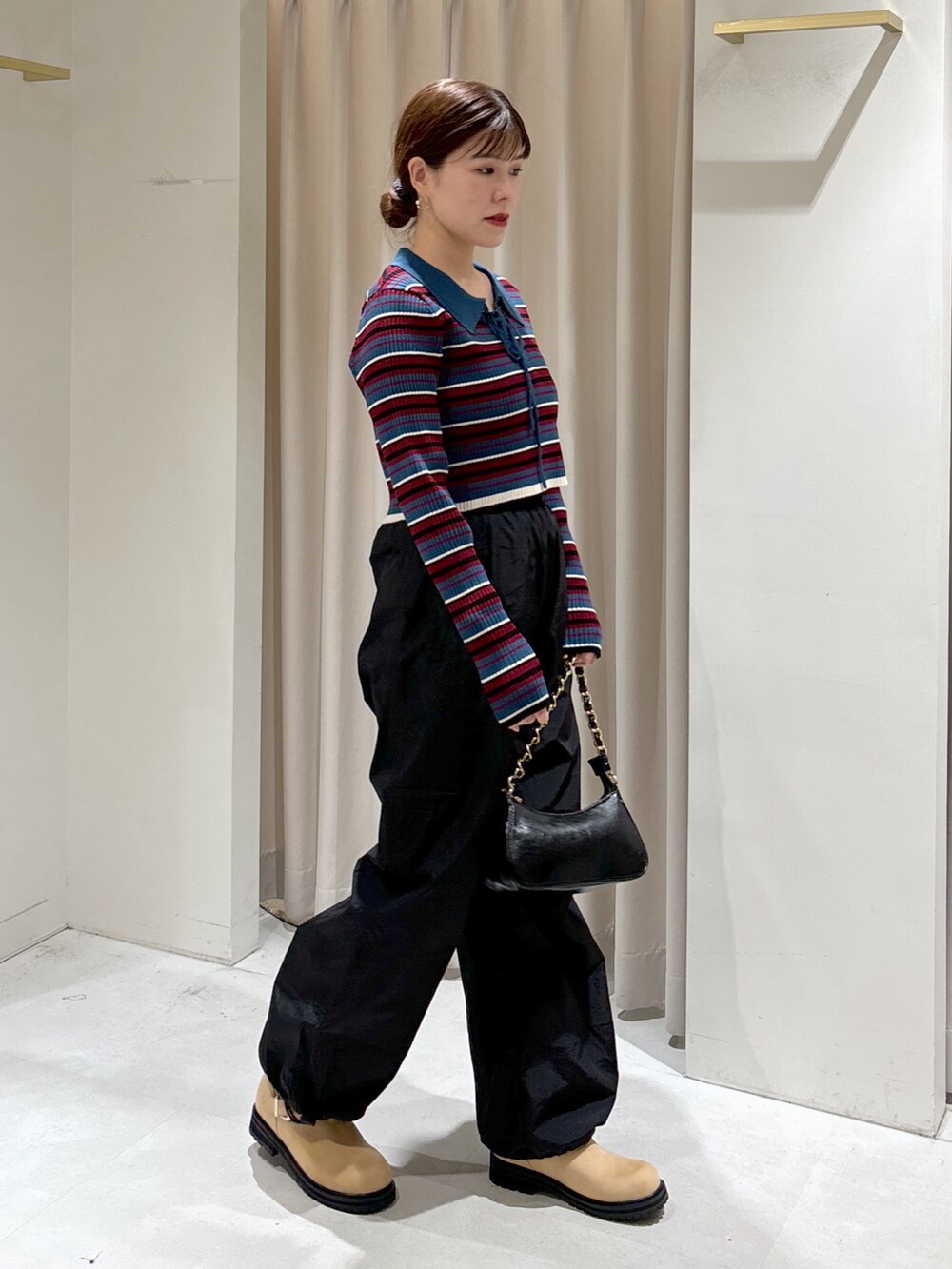 ブルー系のニット/セーター、ブラック系のトートバッグ、ベージュ系のブーツを着用したレディースの秋コーディネートの5枚目の写真