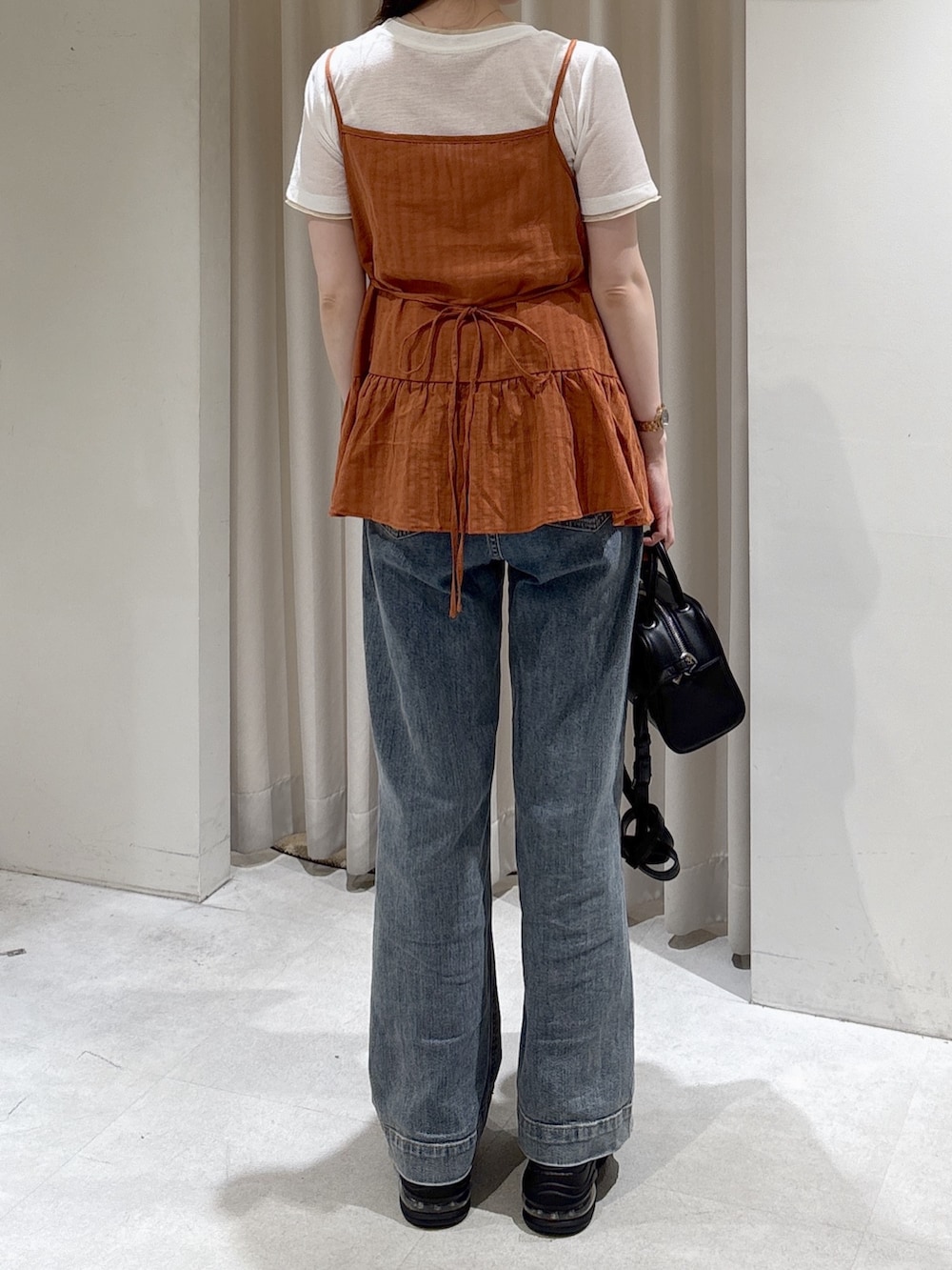 ブラウン系のシャツ/ブラウス、ホワイト系のTシャツ/カットソー、ブラック系のボストンバッグを着用したレディースの春コーディネートの4枚目の写真
