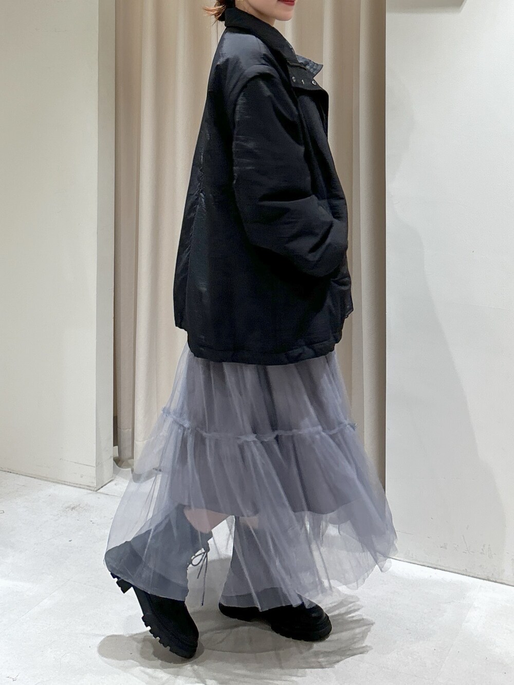 ブラック系のダウンジャケット/コート、グレー系のスカート、ブラック系のブーツを着用したレディースの秋コーディネートの6枚目の写真