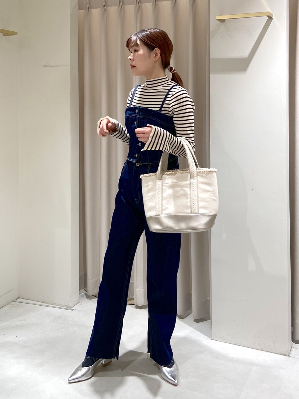 ホワイト系のニット/セーター、ブルー系のベスト、ブルー系のデニムパンツを着用したレディースの冬コーディネートの4枚目の写真