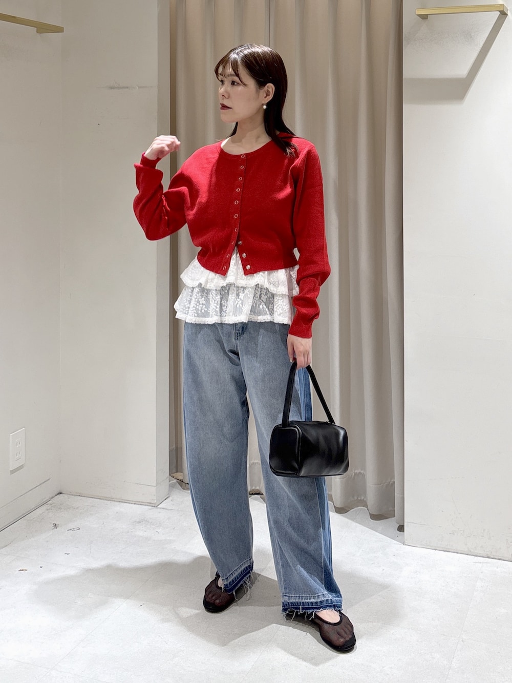 レッド系のニット/セーター、ホワイト系のシャツ/ブラウス、ブラック系のハンドバッグを着用したレディースの冬コーディネートの4枚目の写真