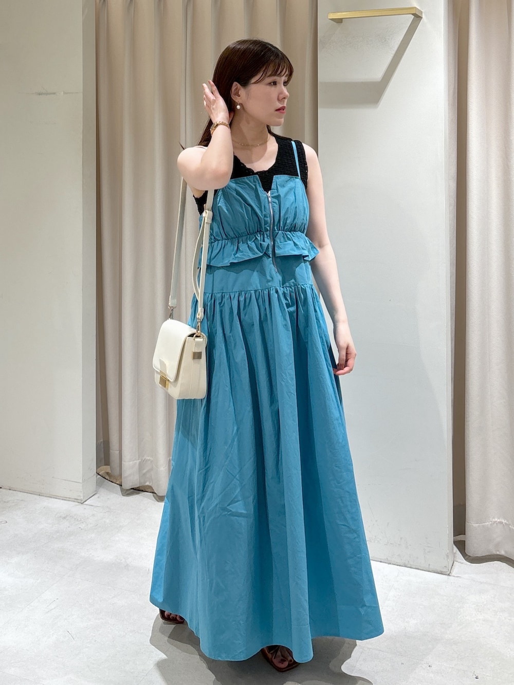 ブルー系のワンピース、ブラック系のタンクトップ、ホワイト系のショルダーバッグを着用したレディースの夏コーディネートの2枚目の写真