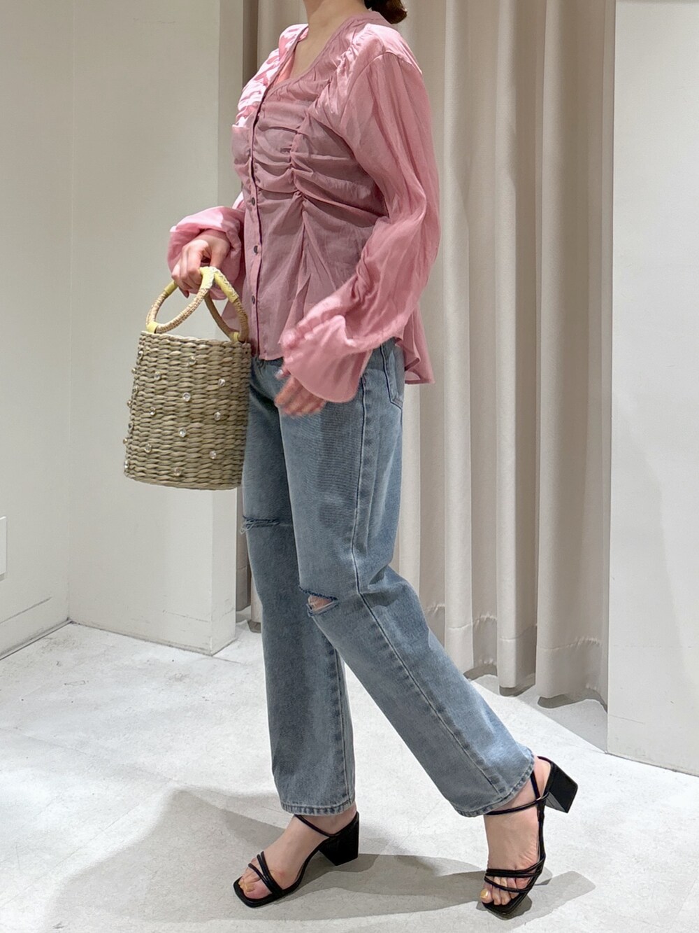 ピンク系のシャツ/ブラウス、イエロー系のかごバッグ、ブルー系のデニムパンツを着用したレディースの春コーディネートの5枚目の写真