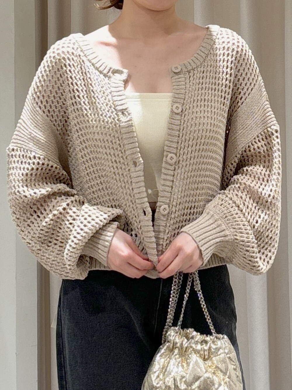 ベージュ系のカーディガン/ボレロ、ホワイト系のキャミソール、ブラック系のデニムパンツを着用したレディースの春コーディネートの3枚目の写真