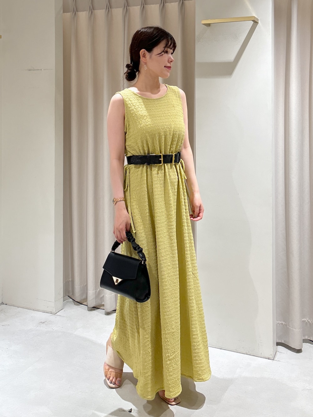 イエロー系のワンピース、ブラック系のショルダーバッグ、グレー系のサンダルを着用したレディースの夏コーディネートの5枚目の写真