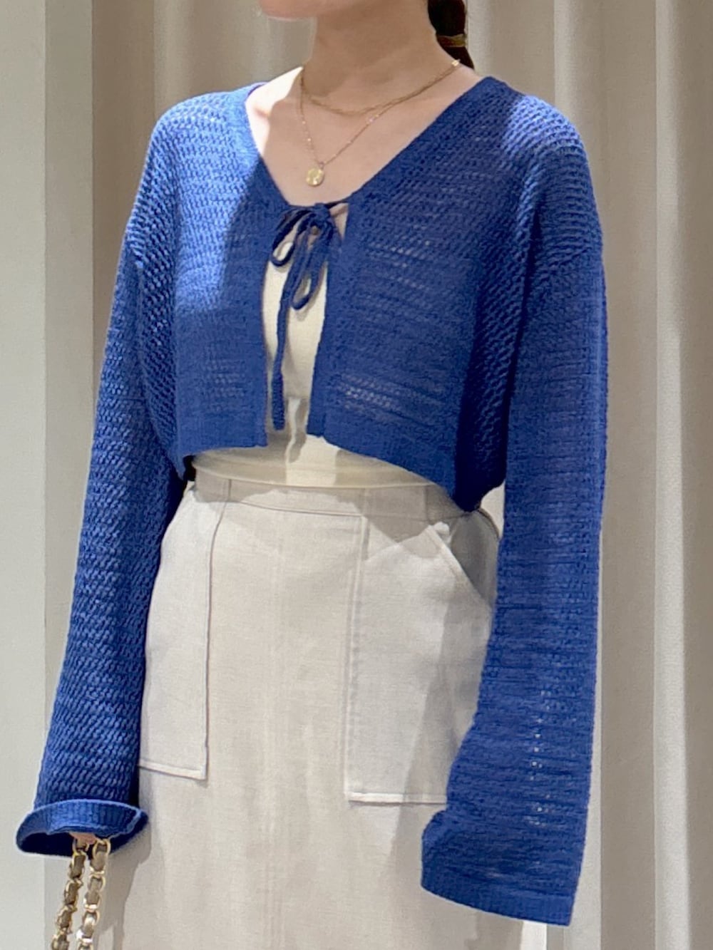 ブルー系のカーディガン/ボレロ、ホワイト系のキャミソール、ベージュ系のトートバッグを着用したレディースの夏コーディネートの4枚目の写真