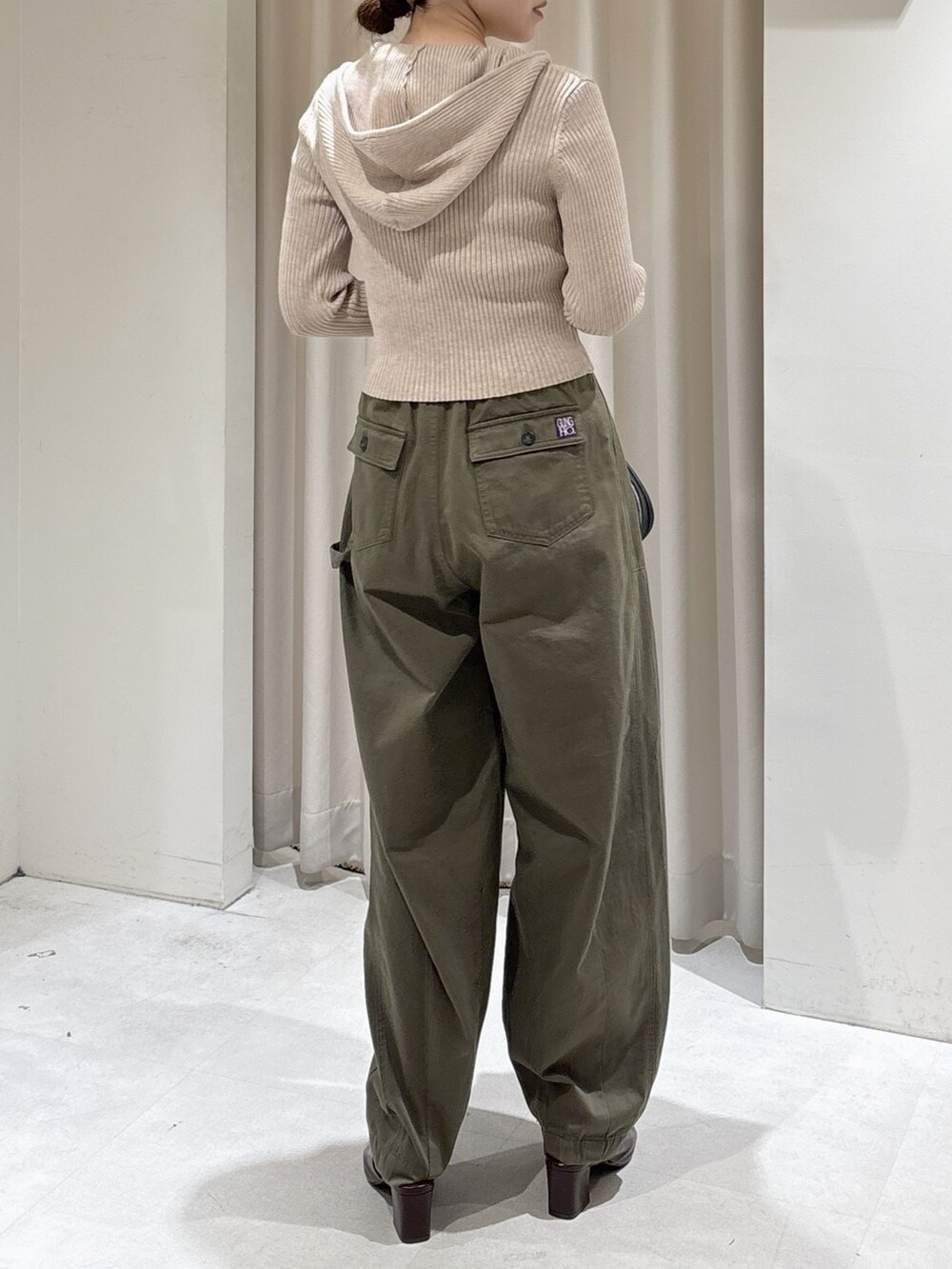 ベージュ系のニット/セーター、ブラック系のハンドバッグ、グリーン系のその他パンツを着用したレディースの秋コーディネートの2枚目の写真