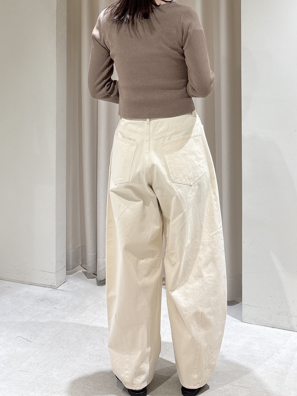 ブラウン系のニット/セーター、ホワイト系のその他パンツ、ブラック系のサンダルを着用したレディースの春コーディネートの4枚目の写真