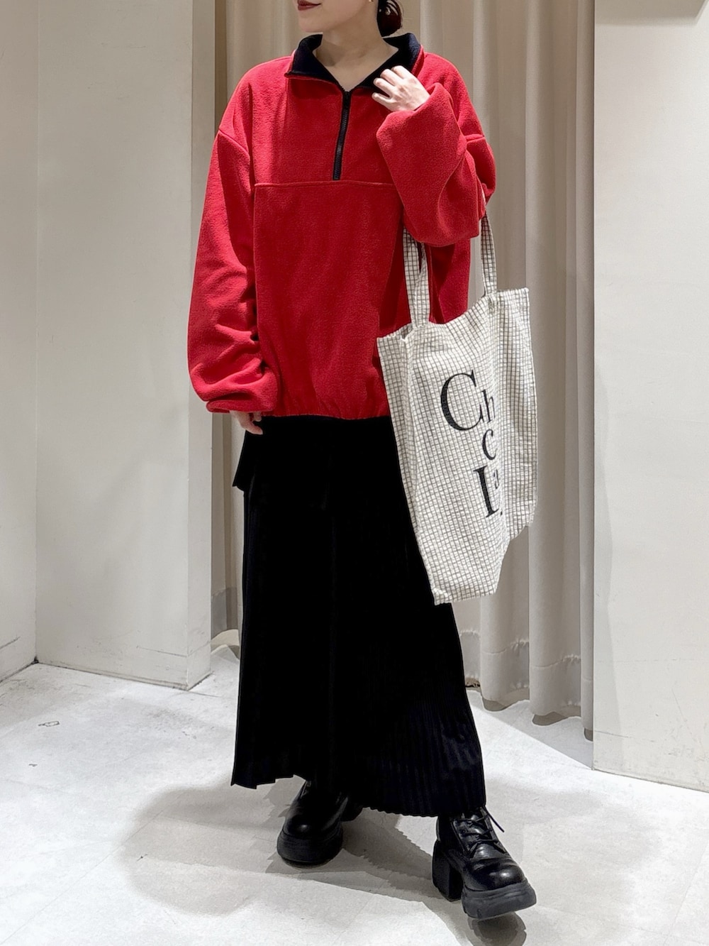 レッド系のスウェット、ホワイト系のニット/セーター、ブラック系のトートバッグを着用したレディースの秋コーディネートの3枚目の写真