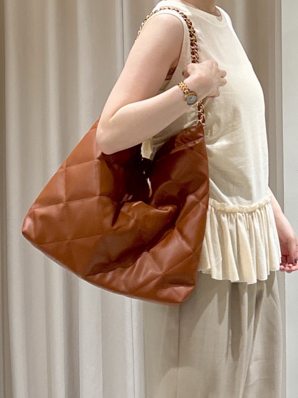 イエロー系のTシャツ/カットソー、ホワイト系のキャミソール、ブラウン系のトートバッグを着用したレディースの夏コーディネートの7枚目の写真