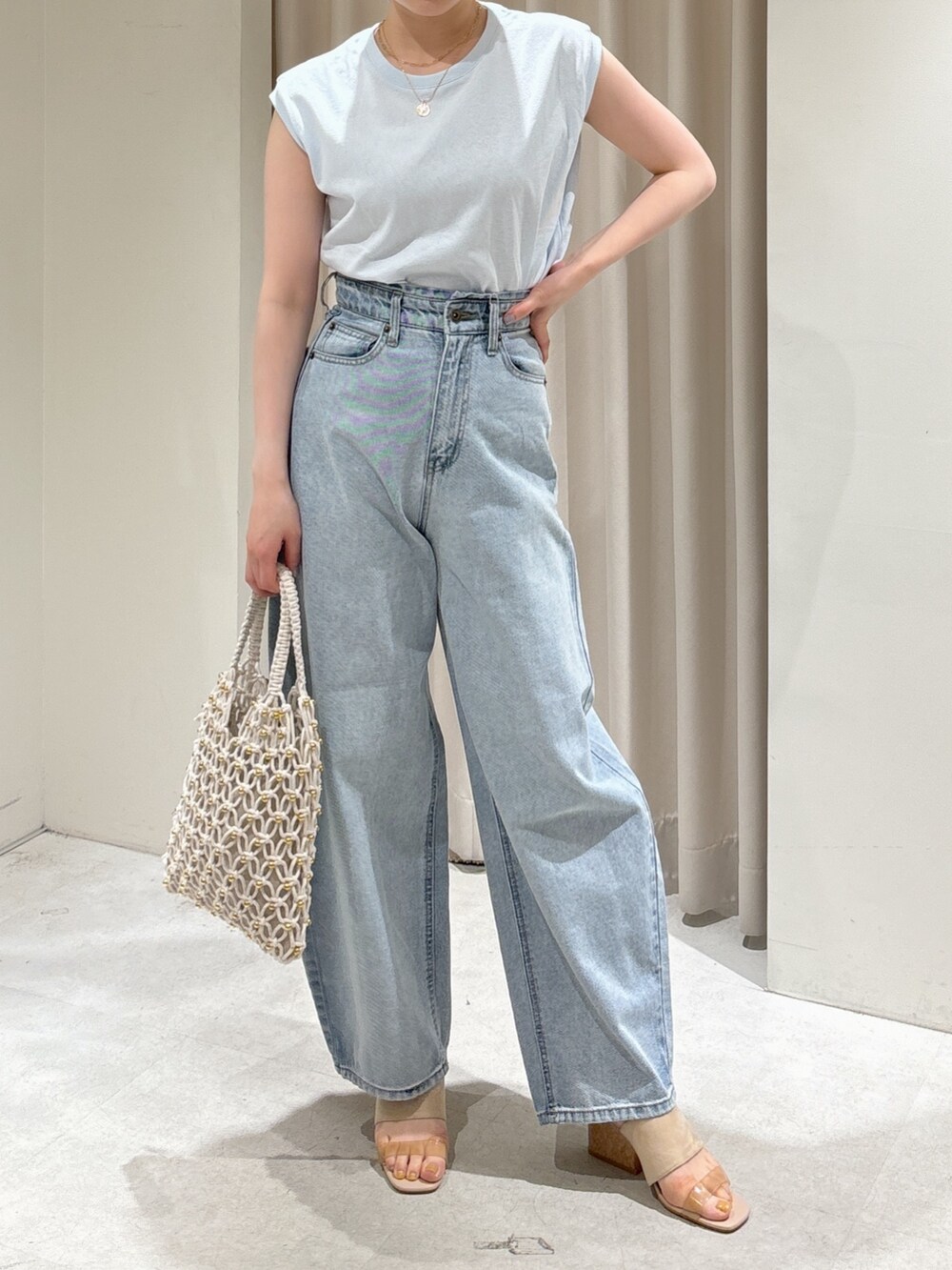 ブルー系のTシャツ/カットソー、ブルー系のデニムパンツ、ホワイト系のハンドバッグを着用したレディースの春コーディネートの8枚目の写真