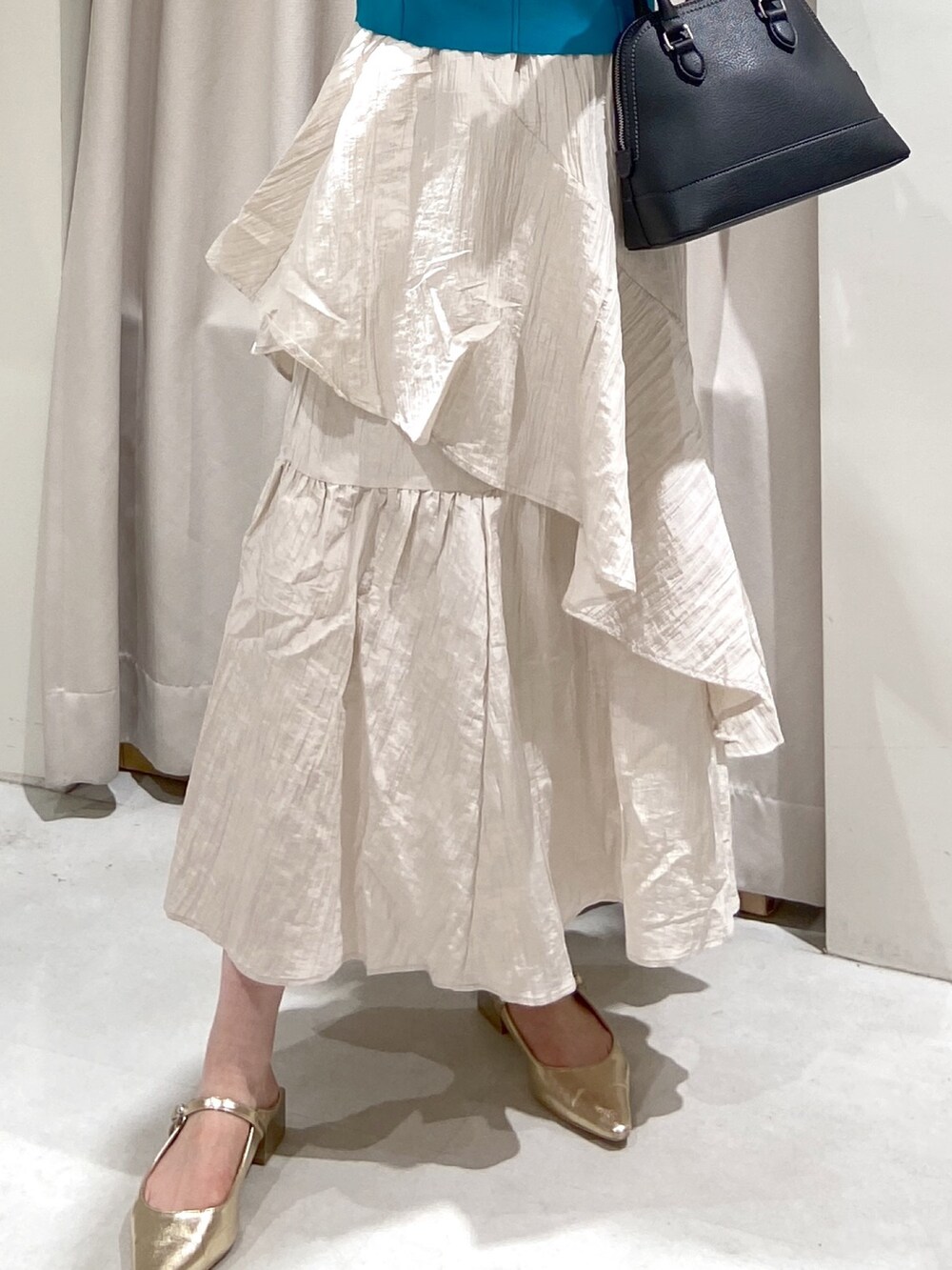 ブルー系のニット/セーター、ホワイト系のスカート、ブラック系のショルダーバッグを着用したレディースの冬コーディネートの6枚目の写真