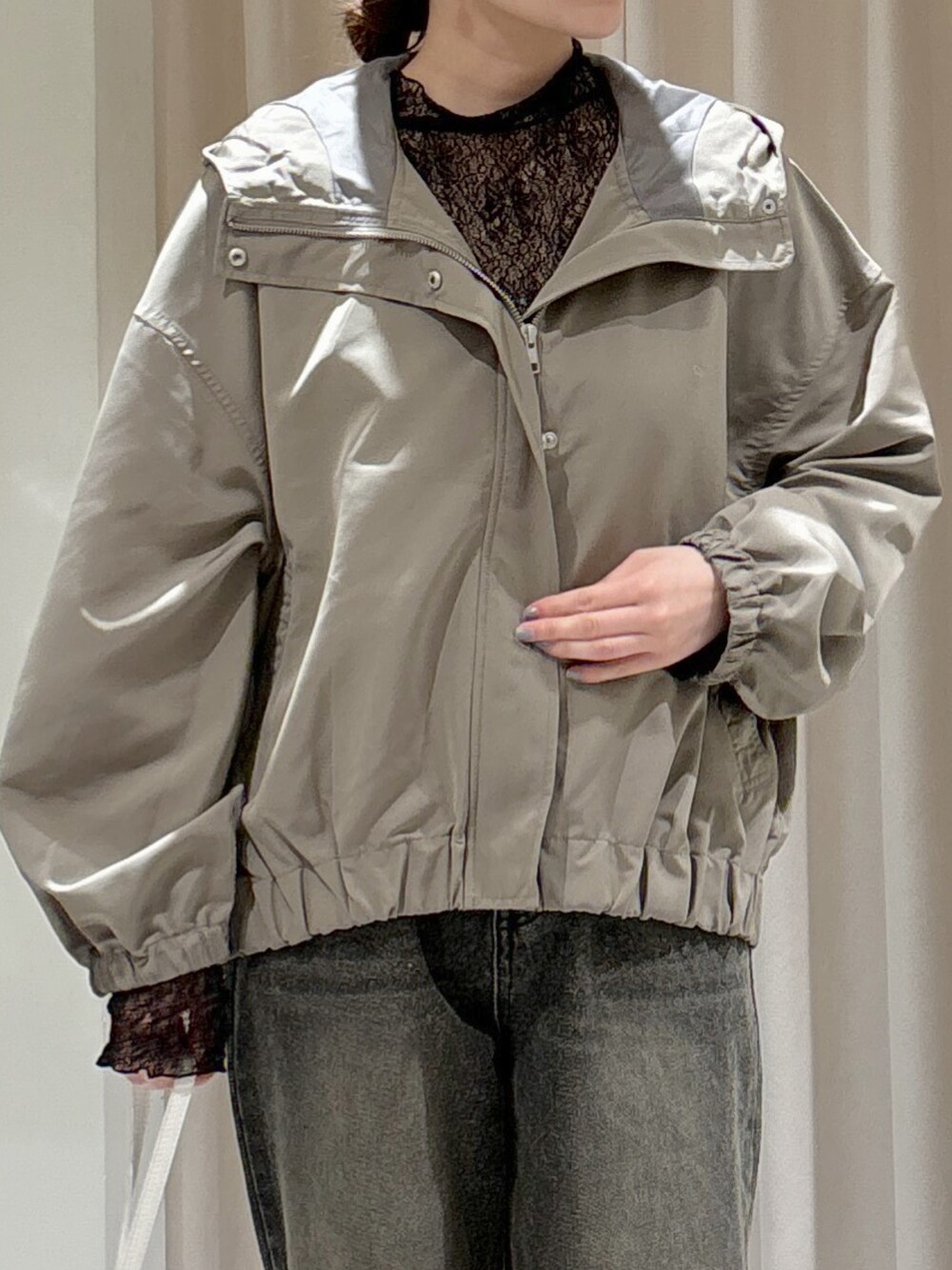 グリーン系のマウンテンパーカー、ブラック系のTシャツ/カットソー、ホワイト系のキャミソールを着用したレディースの冬コーディネートの5枚目の写真