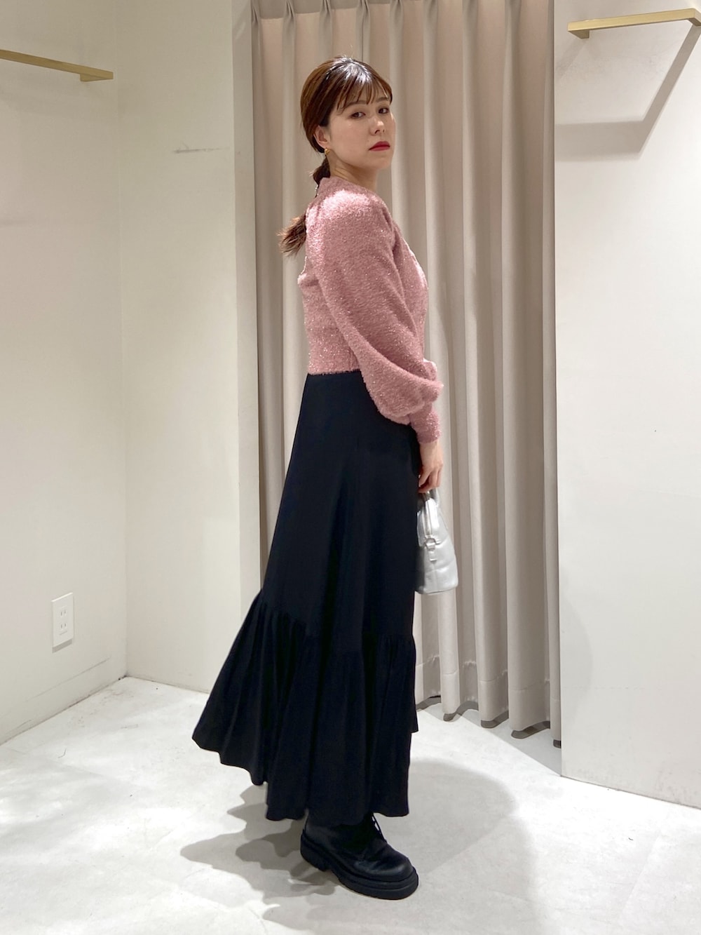 ピンク系のニット/セーター、ブラック系のワンピース、シルバー系のショルダーバッグを着用したレディースの冬コーディネートの3枚目の写真