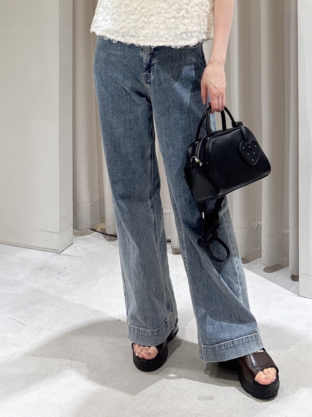 ホワイト系のシャツ/ブラウス、ブルー系のデニムパンツ、ブラック系のボストンバッグを着用したレディースの春コーディネートの4枚目の写真