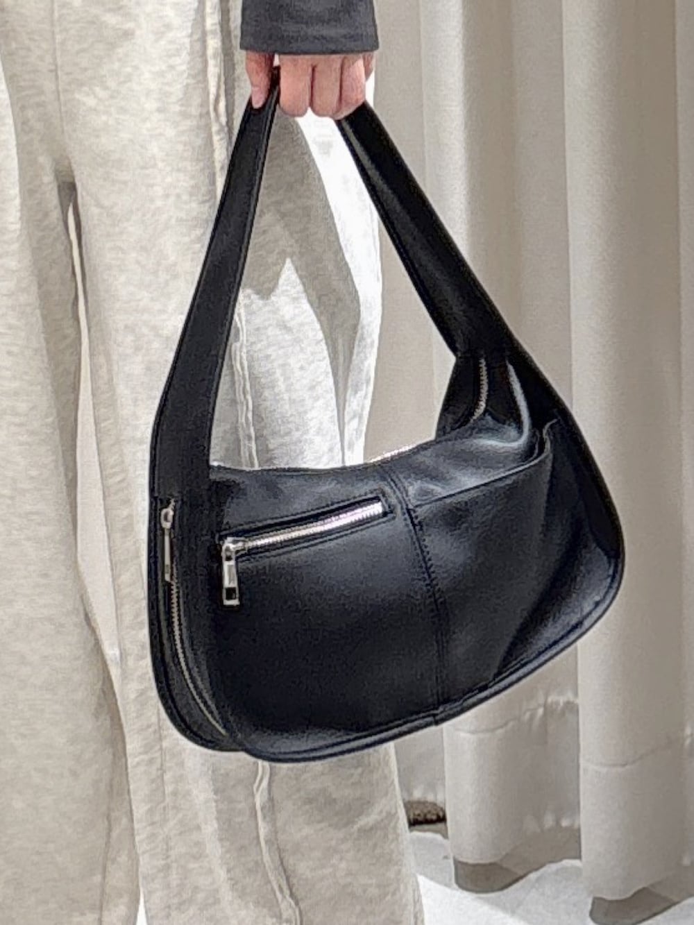 ホワイト系のブルゾン、ブラック系のハンドバッグ、ホワイト系のスウェットパンツを着用したレディースの秋コーディネートの8枚目の写真