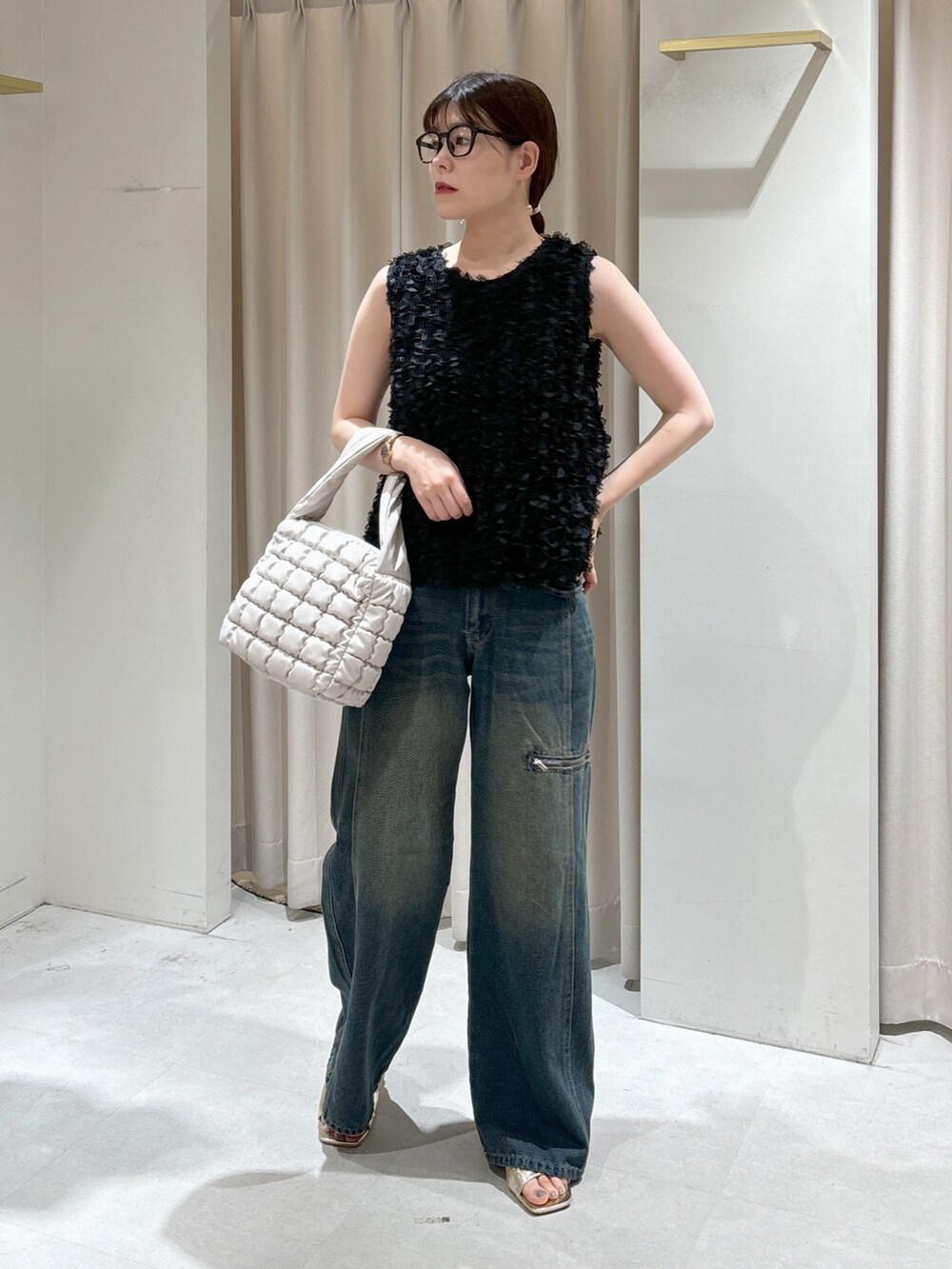 ブラック系のシャツ/ブラウス、ホワイト系のハンドバッグ、ブルー系のデニムパンツを着用したレディースの秋コーディネートの5枚目の写真