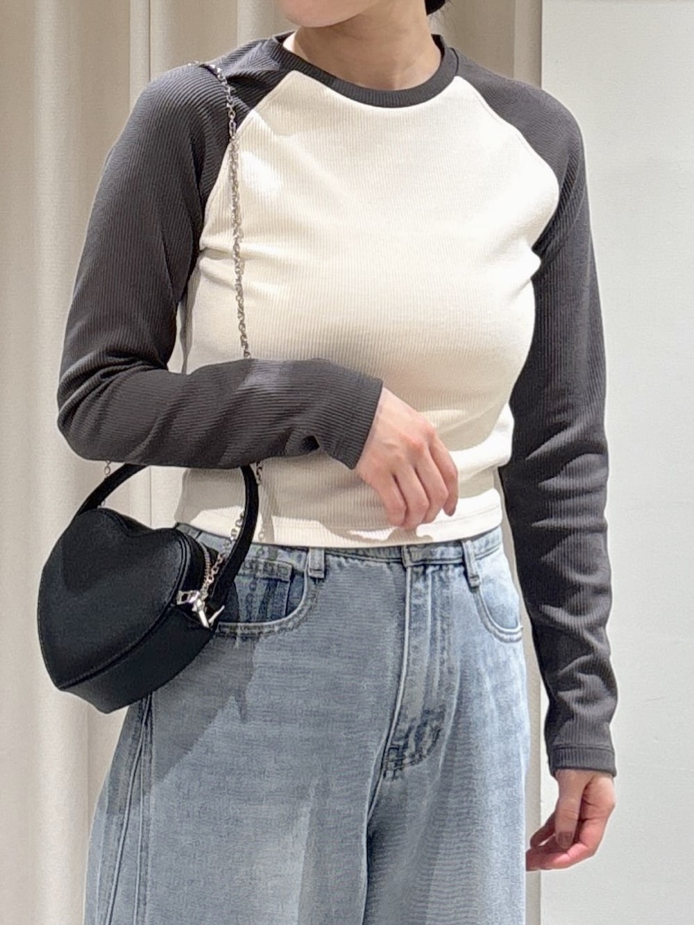 ホワイト系のTシャツ/カットソー、ブルー系のデニムパンツ、ブラック系のショルダーバッグを着用したレディースの冬コーディネートの2枚目の写真