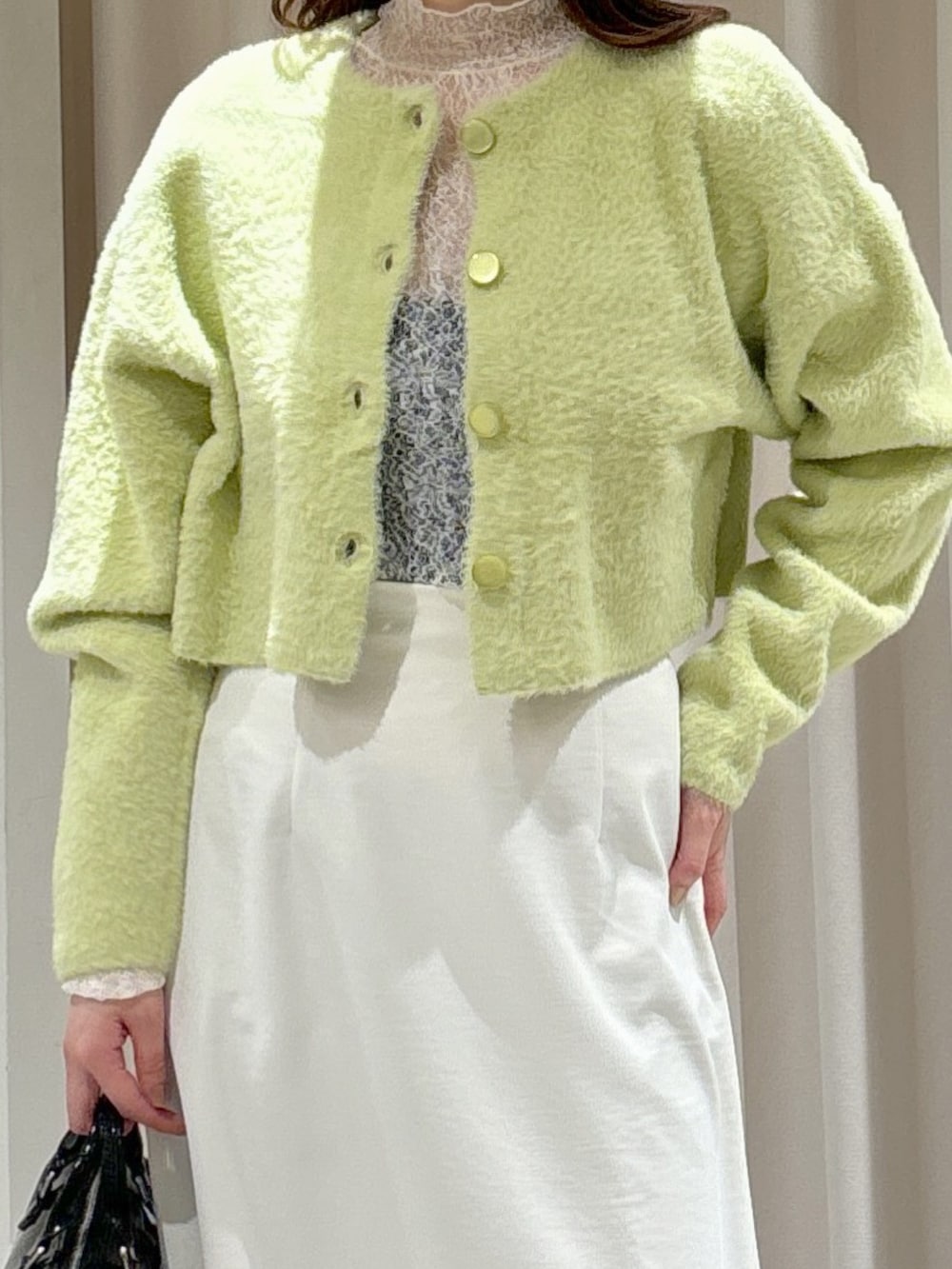 グリーン系のカーディガン/ボレロ、ホワイト系のTシャツ/カットソー、ホワイト系のスカートを着用したレディースの冬コーディネートの4枚目の写真