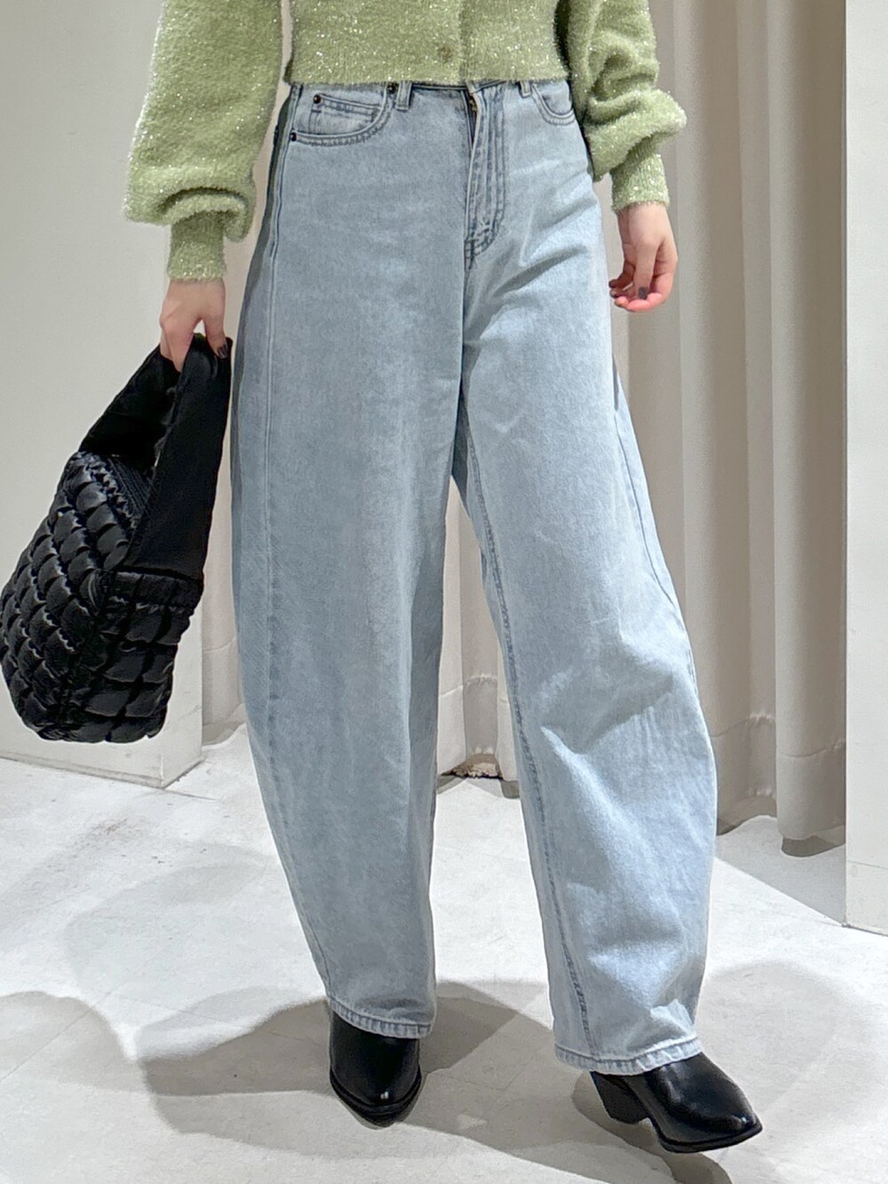 グリーン系のカーディガン/ボレロ、ブルー系のデニムパンツ、ブラック系のハンドバッグを着用したレディースの秋コーディネートの6枚目の写真