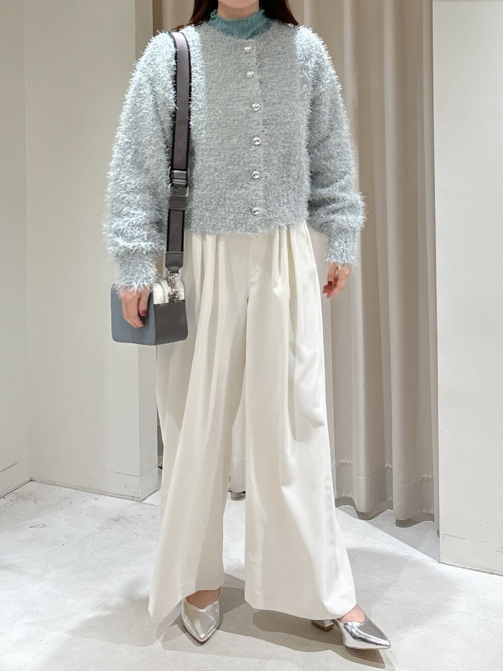 グリーン系のカーディガン/ボレロ、グリーン系のTシャツ/カットソー、ホワイト系のスラックスを着用したレディースの冬コーディネートの8枚目の写真