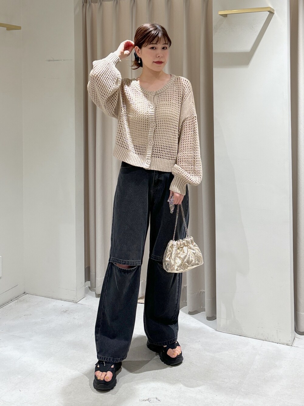 ベージュ系のカーディガン/ボレロ、ホワイト系のキャミソール、ブラック系のデニムパンツを着用したレディースの春コーディネートの4枚目の写真