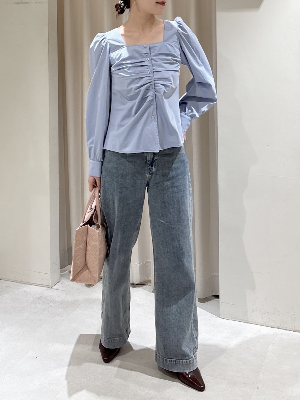 ブルー系のシャツ/ブラウス、ブルー系のデニムパンツ、ピンク系のトートバッグを着用したレディースの冬コーディネートの2枚目の写真