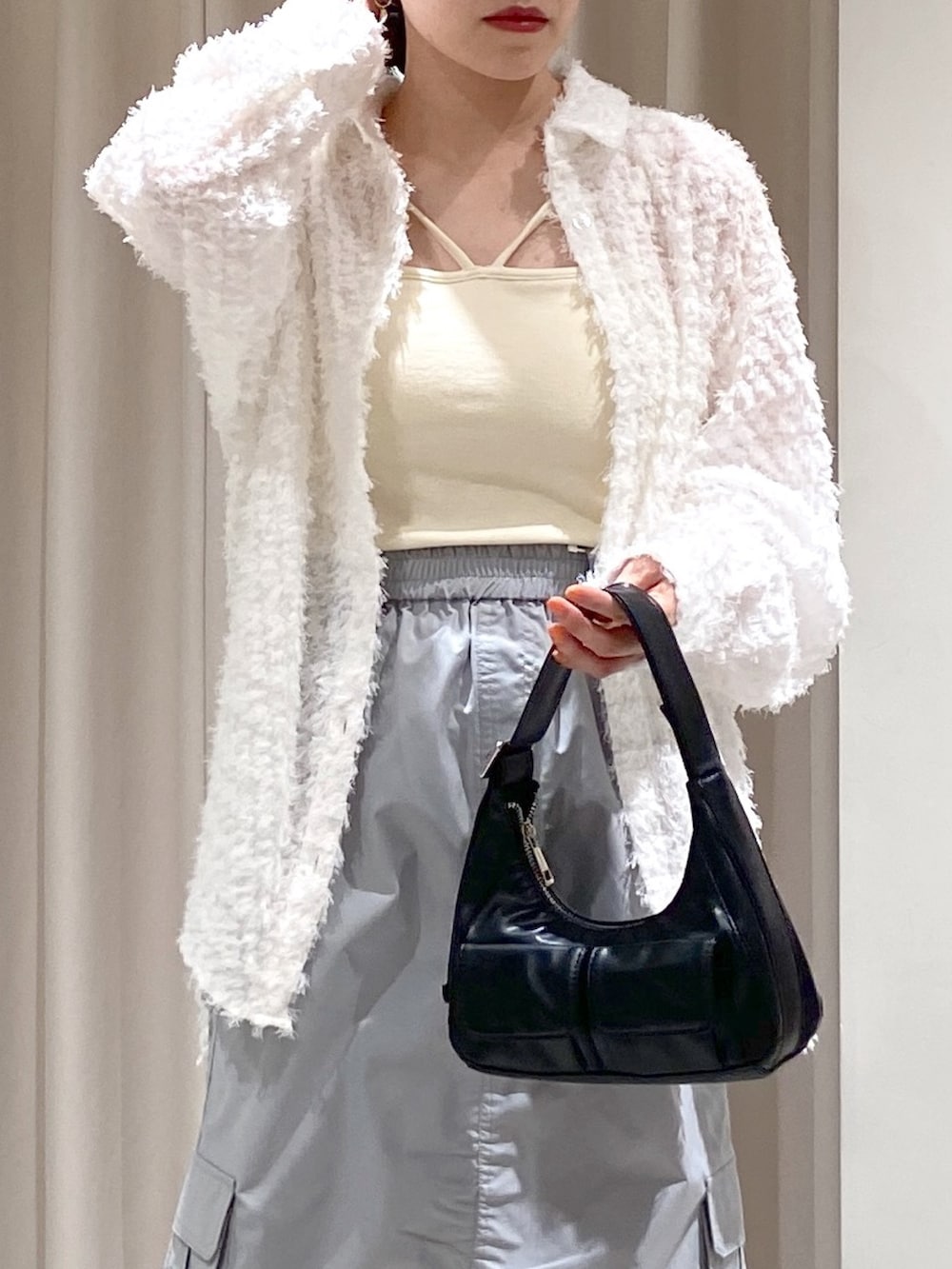 ブラック系のショルダーバッグ、ゴールド系のパンプス、ホワイト系のシャツ/ブラウスを着用したレディースの冬コーディネートの2枚目の写真