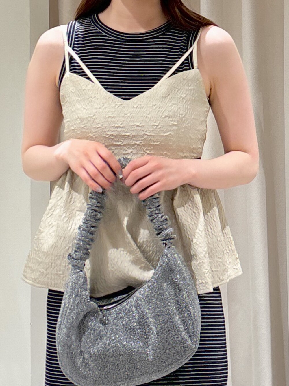 ホワイト系のシャツ/ブラウス、ブラック系のサンダル、シルバー系のハンドバッグを着用したレディースの春コーディネートの4枚目の写真