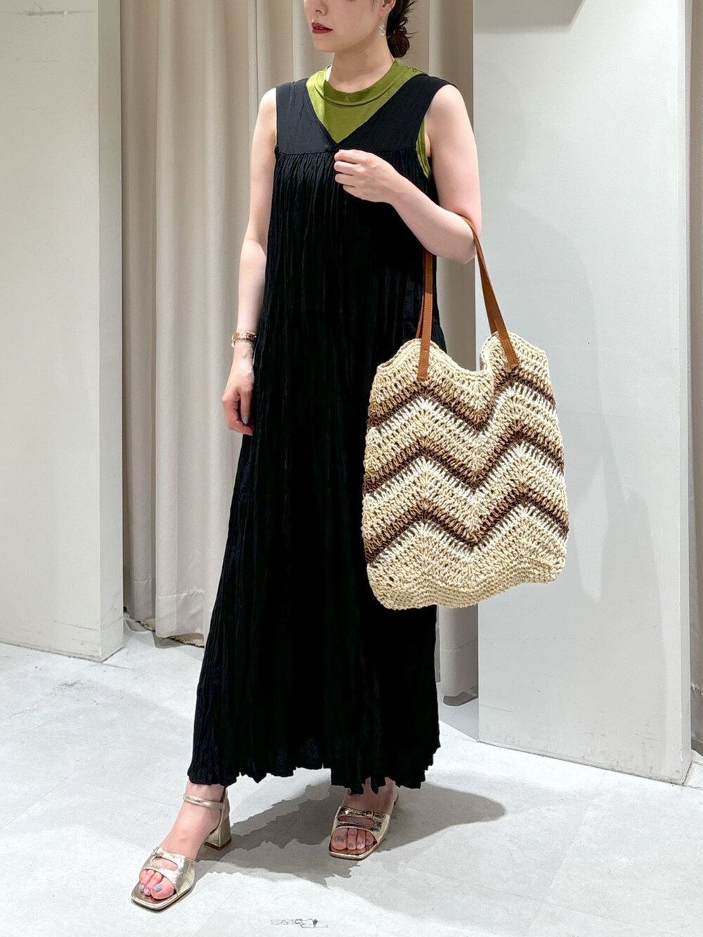 ブラック系のワンピース、ベージュ系のトートバッグ、ゴールド系のサンダルを着用したレディースの夏コーディネートの7枚目の写真