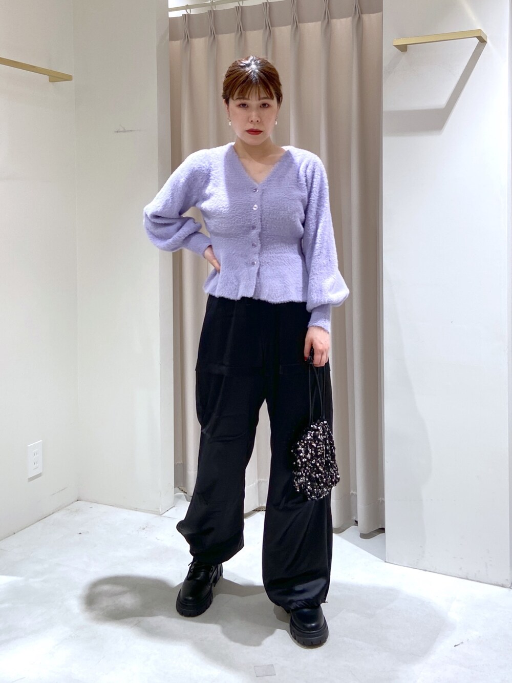 パープル系のカーディガン/ボレロ、ブラック系のハンドバッグ、ブラック系のカーゴパンツを着用したレディースの秋コーディネートの3枚目の写真