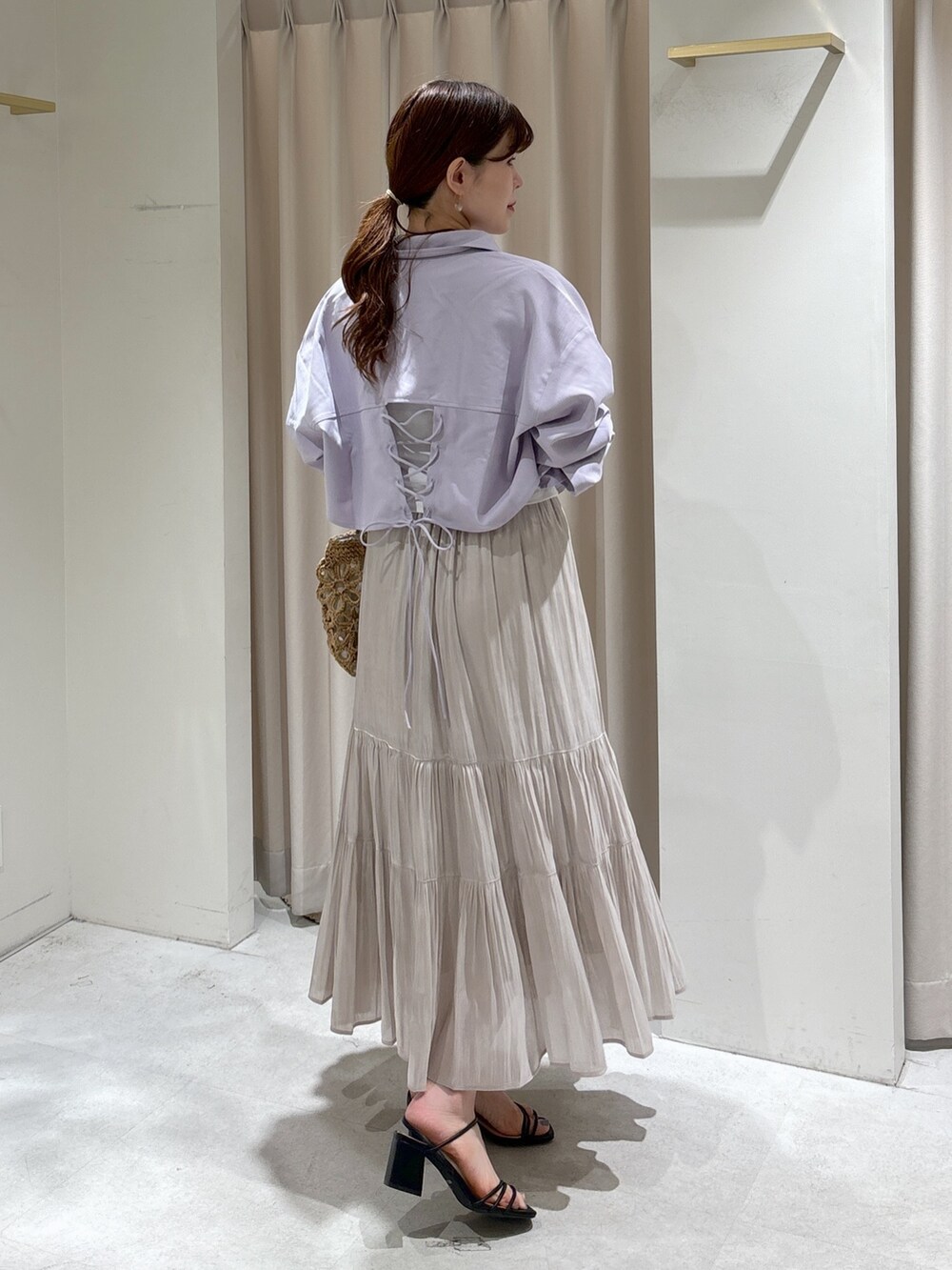パープル系のシャツ/ブラウス、ホワイト系のTシャツ/カットソー、ベージュ系のかごバッグを着用したレディースの夏コーディネートの3枚目の写真