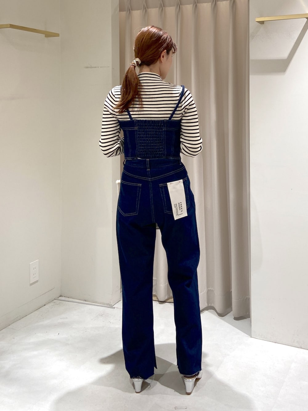 ホワイト系のニット/セーター、ブルー系のベスト、ブルー系のデニムパンツを着用したレディースの冬コーディネートの2枚目の写真