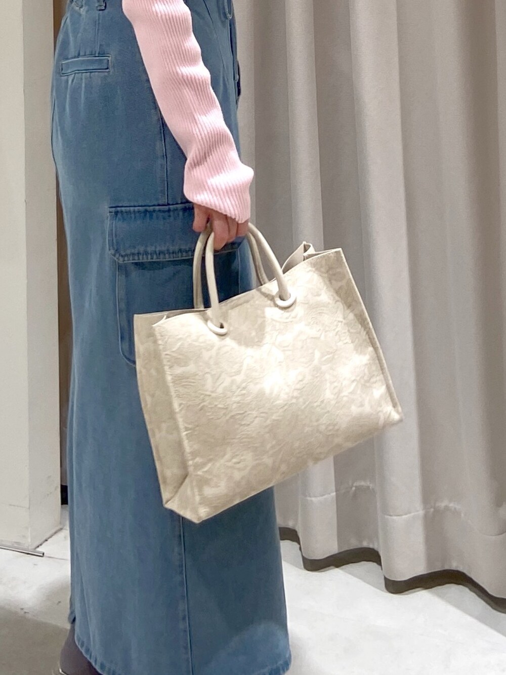 ブルー系のデニムスカート、ホワイト系のトートバッグ、シルバー系のパンプスを着用したレディースの冬コーディネートの5枚目の写真