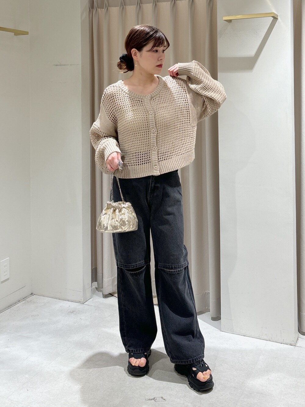 ベージュ系のカーディガン/ボレロ、ホワイト系のキャミソール、ブラック系のデニムパンツを着用したレディースの春コーディネートの5枚目の写真